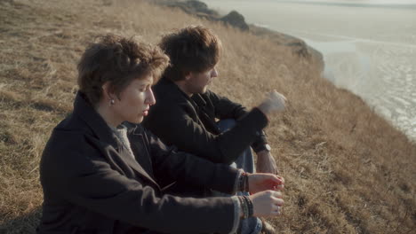 couple overlooking frozen lake and having conversation