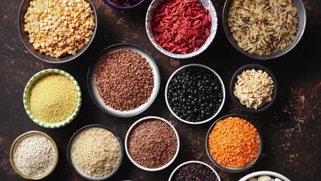 Various-superfoods-in-smal-bowls-on-dark-rusty-background