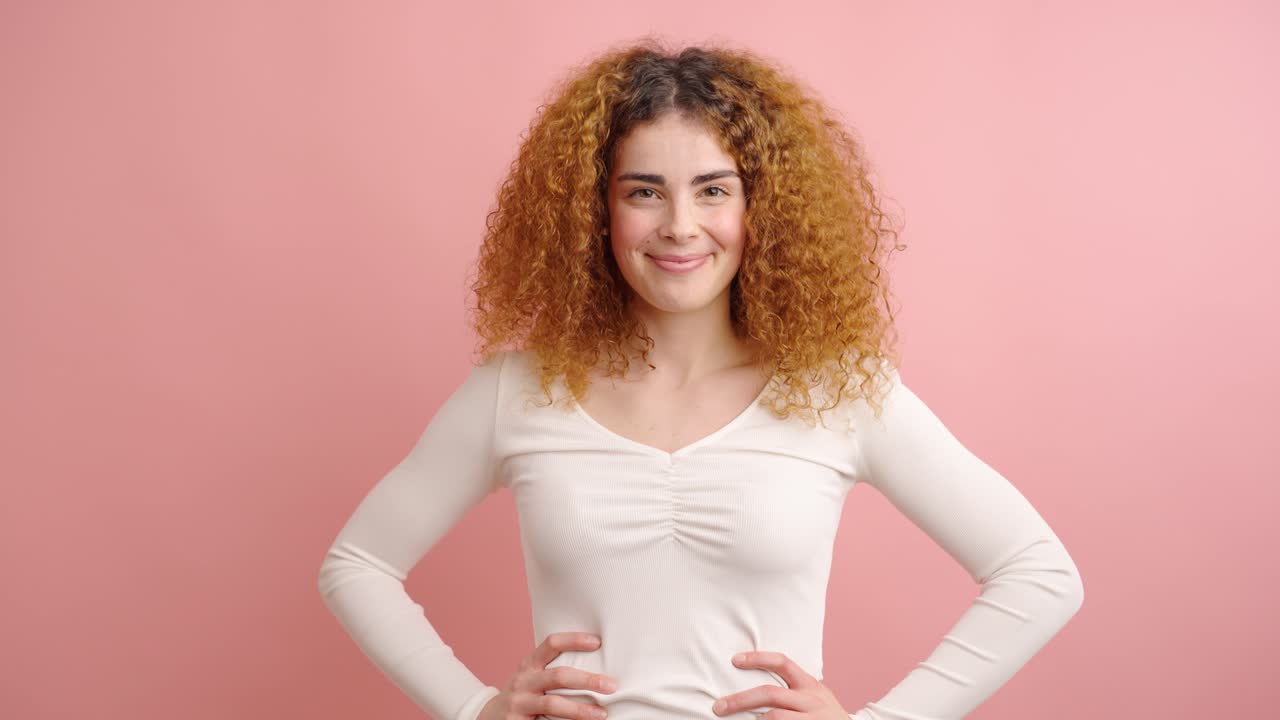 Young woman expressing happiness on pink background
