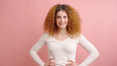 young woman expressing happiness on pink background