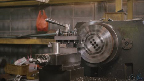 professional machinist operating lathe grinding metal machine metalworking industrial manufacturing factory