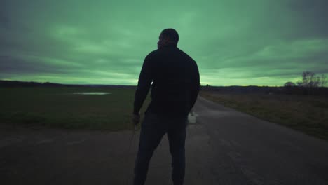 Modern-Black-Swordsman-Warrior-Awaiting-Battle-Opponent-in-Open-Field-Under-Green-Sky,-Europe,-4K-|-Muscular,-Intimidating,-Shadow,-Figure,-Blurry,-Dark-Clothes,-Powerful,-Patrol,-Turning