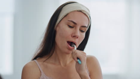 Lazy-model-cleaning-mouth-looking-mirror-at-bath-close-up.-Woman-morning-routine