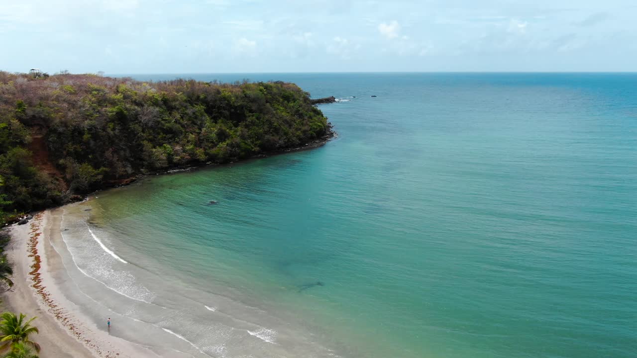 la tranquila playa de segresse en granada con aguas claras y una sola persona caminando, vista aérea