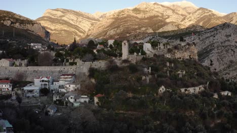 AERIAL---Town-of-Stravi-Bar-and-mountains,-Bar,-Crmnica,-Montenegro,-truck-right