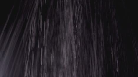 jets of water pouring on a black background. the rain is pouring down, texture