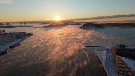 golden hour sunset on horizon with fog over waters in bjorvika, oslo