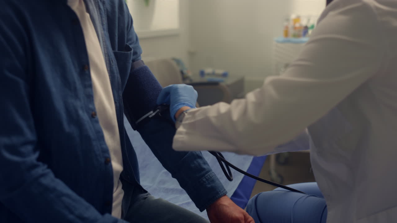 manos del médico poniendo el brazalete médico en el brazo del paciente de cerca. medición de presión