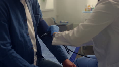 physician hands putting medical cuff on patient arm close up. measuring pressure