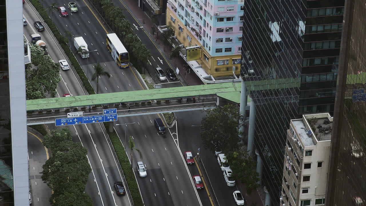 Overhead view of traffic and pedestrian walkway on the Gloucester Road, Wan Chai, Hong Kong, China. Handheld static long lens shot