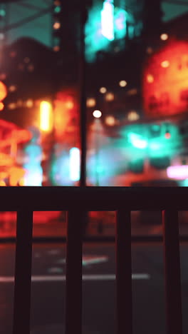 neon lights reflecting on a metal fence at night