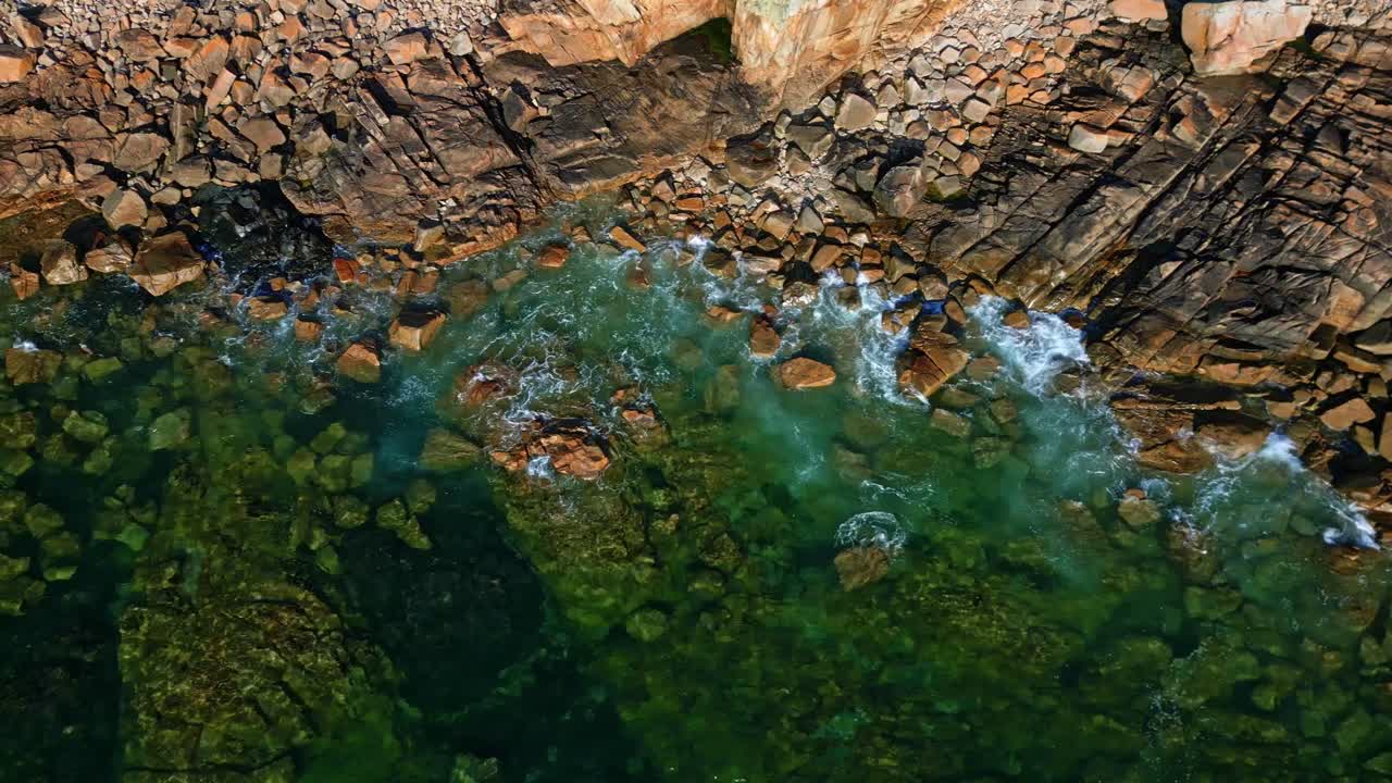 Ripresa aerea dall’alto con drone di onde oceaniche che si infrangono contro le rocce sulla costa bretone della Francia