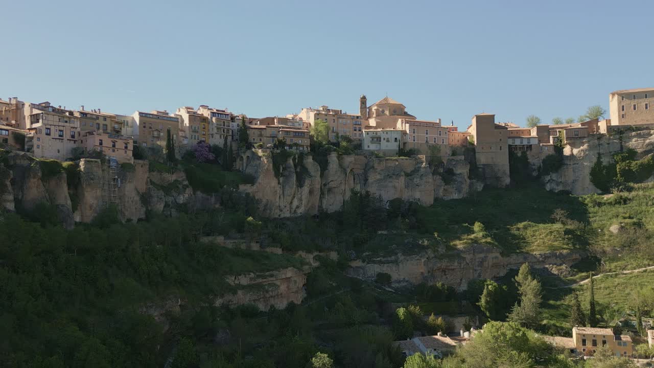 Houses hanging next to rocky precipice. Zoom in aerial view of medieval houses next to a cliff. Cuenca. Spain.