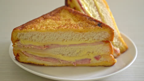 Sándwich de jamón y queso casero en la placa blanca.