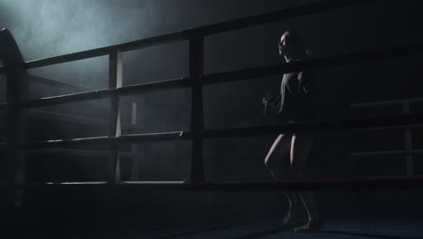 female athlete training with jump rope in a smoky boxing ring
