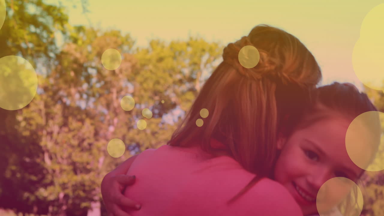 Animazione con effetto bokeh su felice madre e figlia caucasiche che si abbracciano.