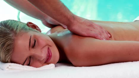 Friedliche-Blondine-Bekommt-Eine-Massage-Am-Pool