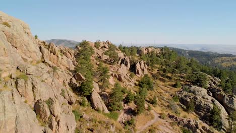 colpo di drone di terreno montuoso, escursionisti e paesaggio urbano in lontananza