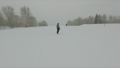 POV-shot-of-people-riding-on-a-snowboard-in-slow-motion