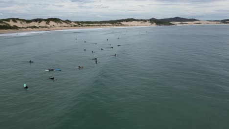 surfers waiting for the perfect wave at one mile beach nsw australia
