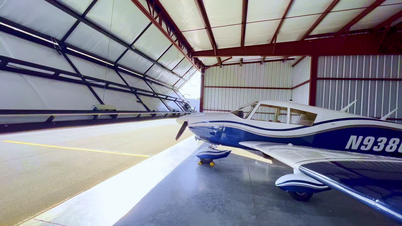 abridor automático de la puerta del hangar para revelar el piper cherokee 180
