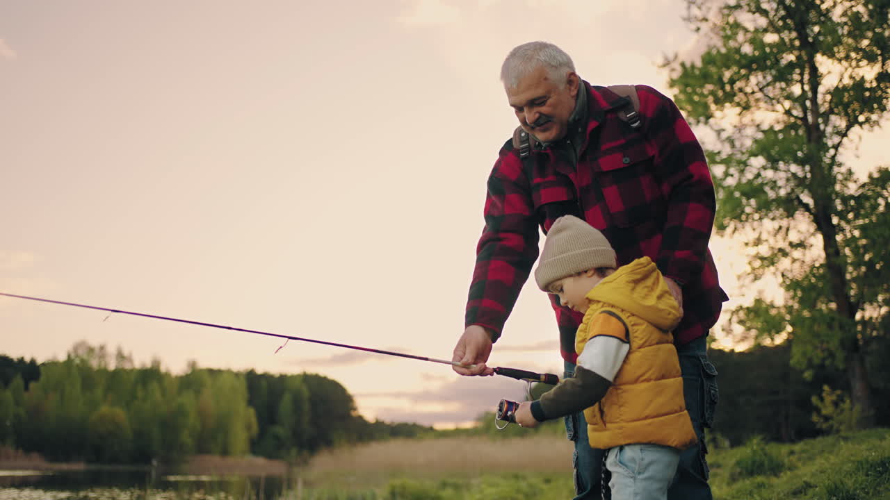 el abuelo feliz y el nieto están pescando juntos