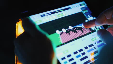 a professional sound engineer uses a tablet near the stage controls the sound of the music group hd