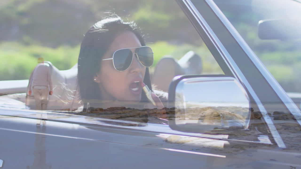 Driving convertible with scenic landscape reflection, woman wearing sunglasses