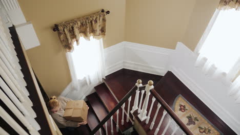 young multi-ethnic couple carry boxes up the stairs 02