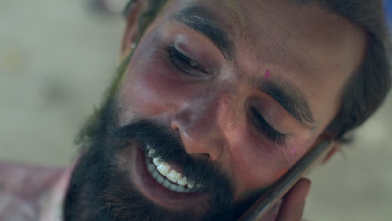 인도인 남자의 얼굴 클로즈업은 밝은 홀리 색으로 얼룩져 있습니다.