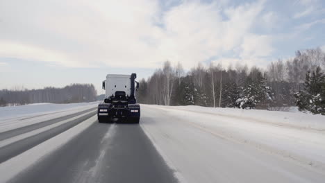 camión de invierno conduciendo en una carretera nevada