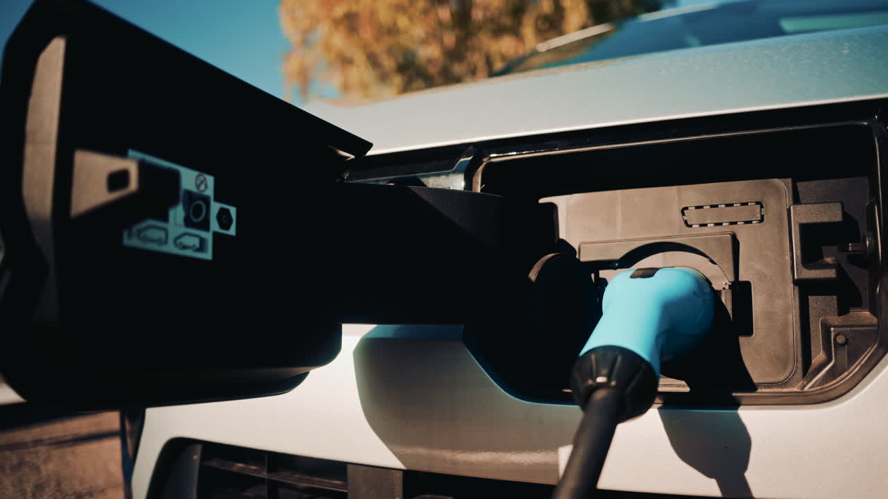 Close up shot of an electric vehicle charging port with cable connected