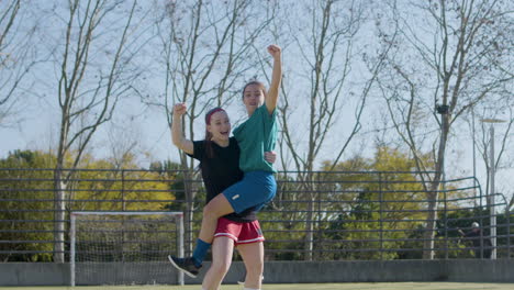 two teenage girls jumping with joy after successful goal