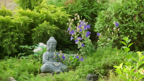 Chinese-zen-garden-with-buddha-and-temple-among-green-shrubs-Pull-reveal-shot