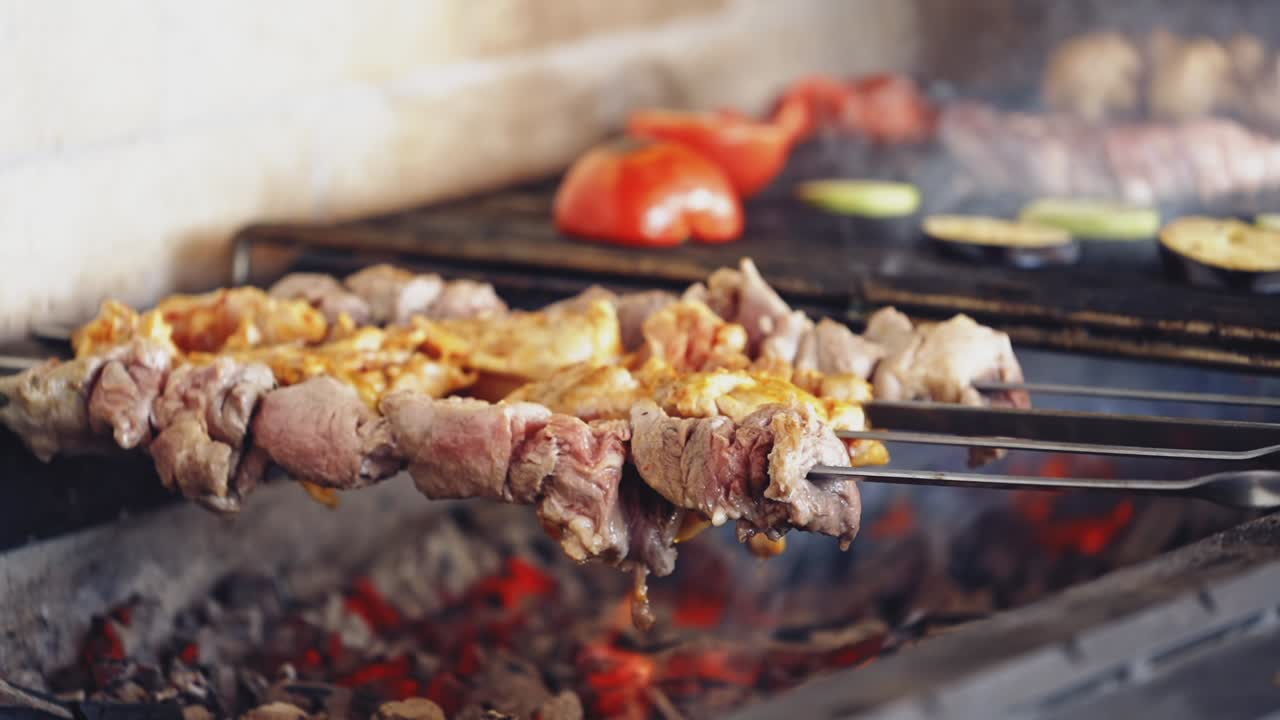 Barbeque on a stove. Meat and vegetables being grilled. Juicy meat and vegetables on coals. Kebab on metal skewers barbecue.