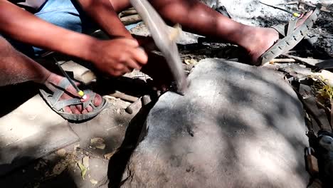 A-close-up-on-a-dark-skinned-man-using-home-made-tools-in-Africa-on-a-sunny-day