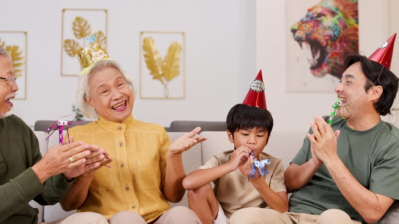 Elderly couple and child enjoy a lively birthday celebration with party hats and whistles in a colorful, cheerful setting