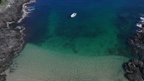 un barco anclado en una pequeña playa entre dos pequeñas islas en costa rica