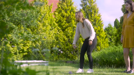 side view of caucasian young woman playing petanque in the park on a sunny day