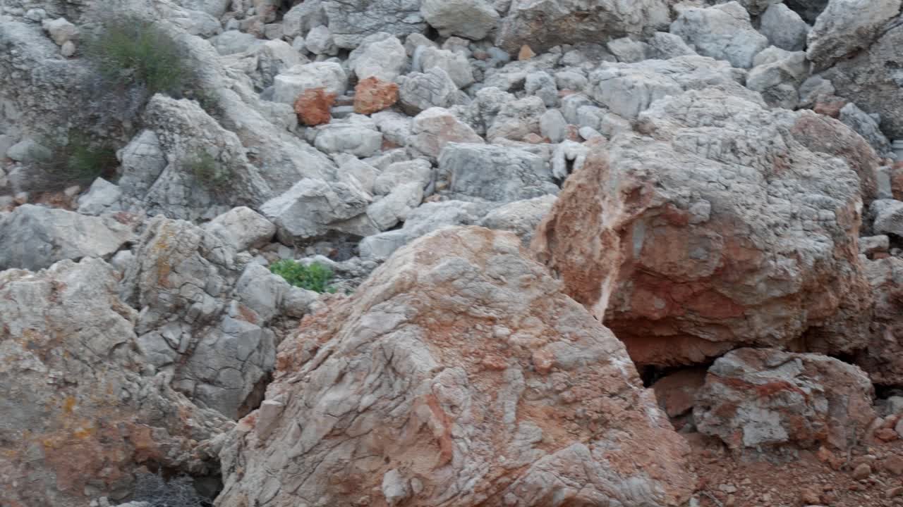 Rocky terrain at Cala Viola De Levant, Menorca with vegetation in the gaps