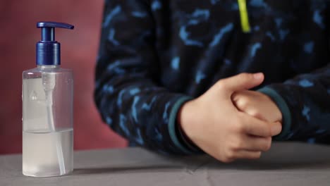 las manos del niño se frotan para la desinfección contra el coronavirus pandémico