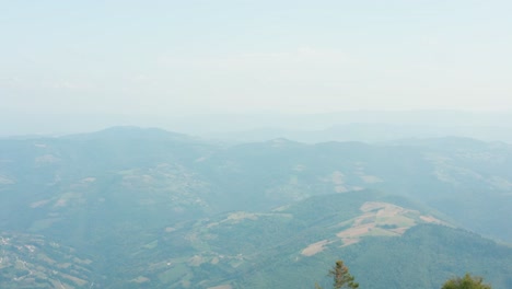 aerial reveal over mountaintop peak, dramatic drop over mountainside valley