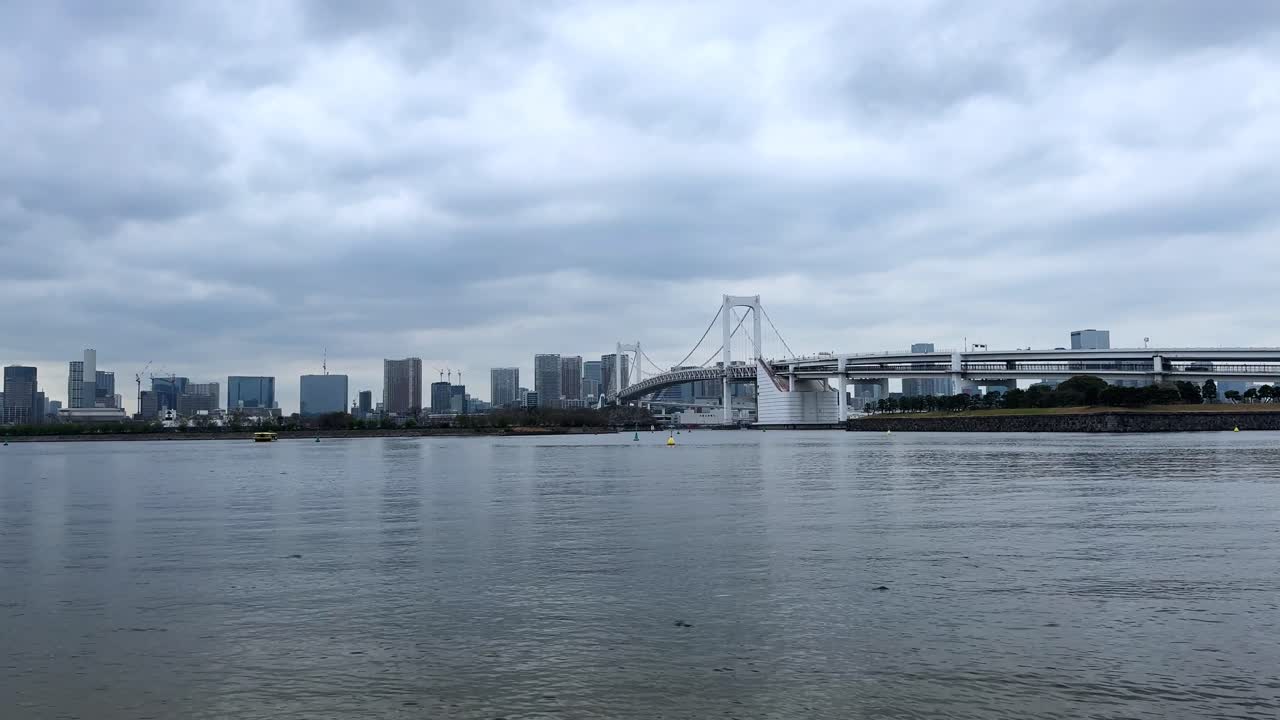 Tokyo cityscape skyline on a cloudy day with the iconic Rainbow Bridge in view
