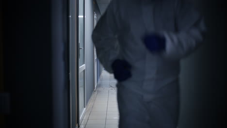 person in protective gear running down a corridor