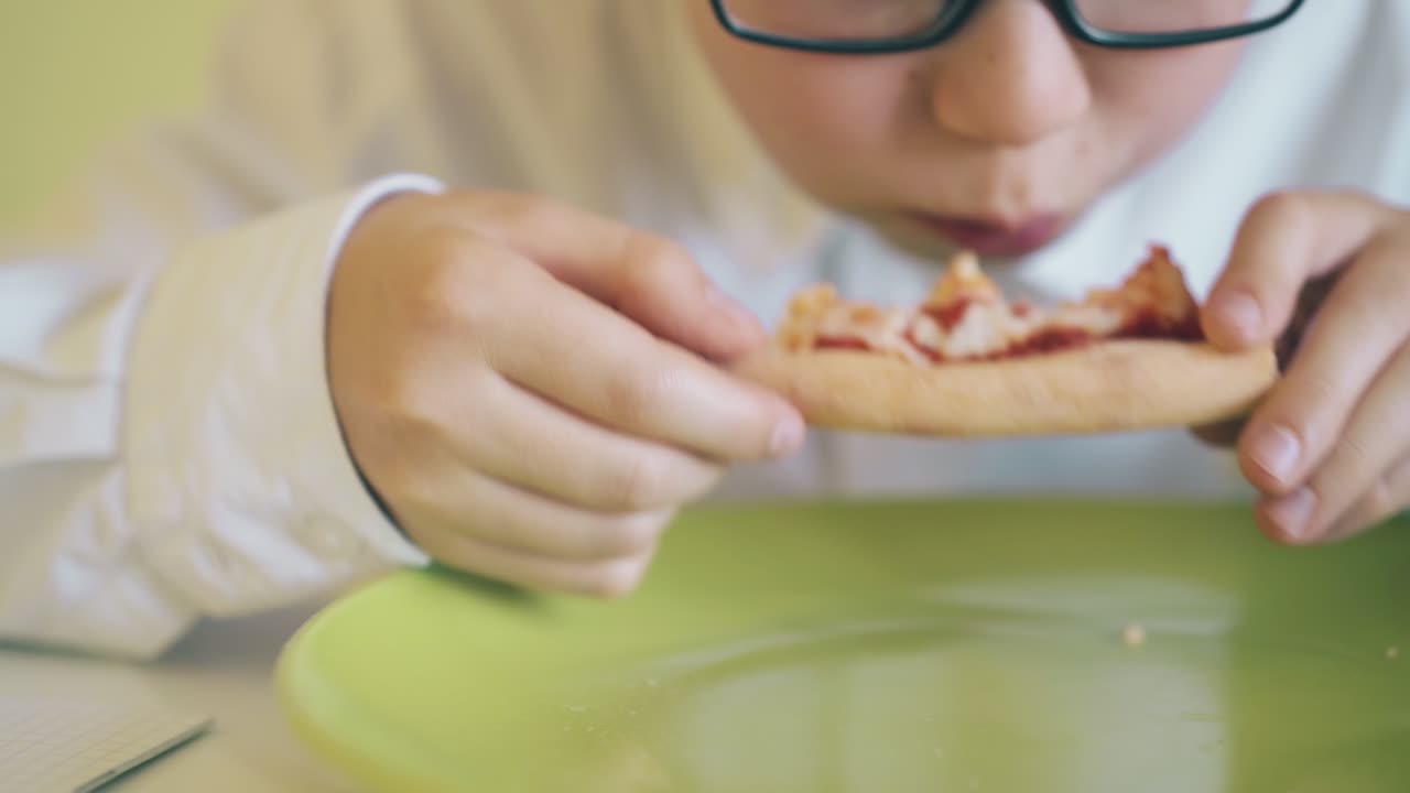 estudiante en gafas tiene cena con pizza fresca en la mesa