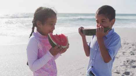 Glücklicher-Hispanischer-Bruder-Und-Schwester,-Die-Am-Strand-Wassermelone-Essen