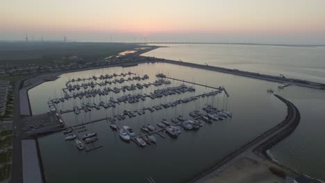 Antenne:-Sonnenuntergang-An-Einem-Freizeithafen-In-Den-Niederlanden-Mit-Blick-Auf-Das-Oosterschelde-Sturmflutwehr