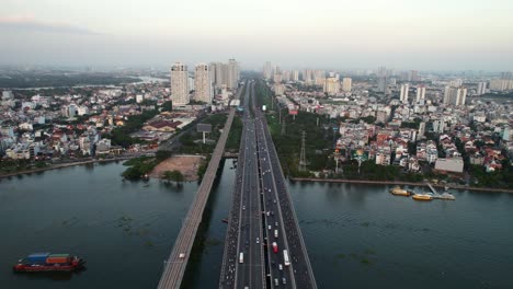 aerial of cars and motorbikes driving over a bridge on a long highway road in ho chi minh city vietnam at sunset