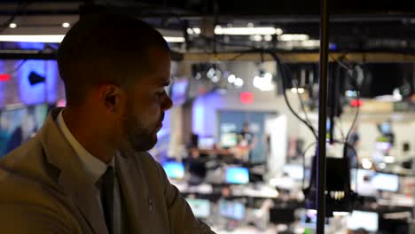 Rack-focus-of-business-man-looking-out-over-busy-office