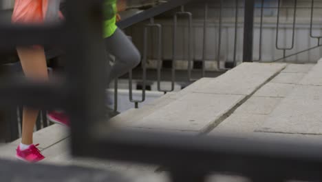 legs of three athletic women running up a stairway in the outdoors